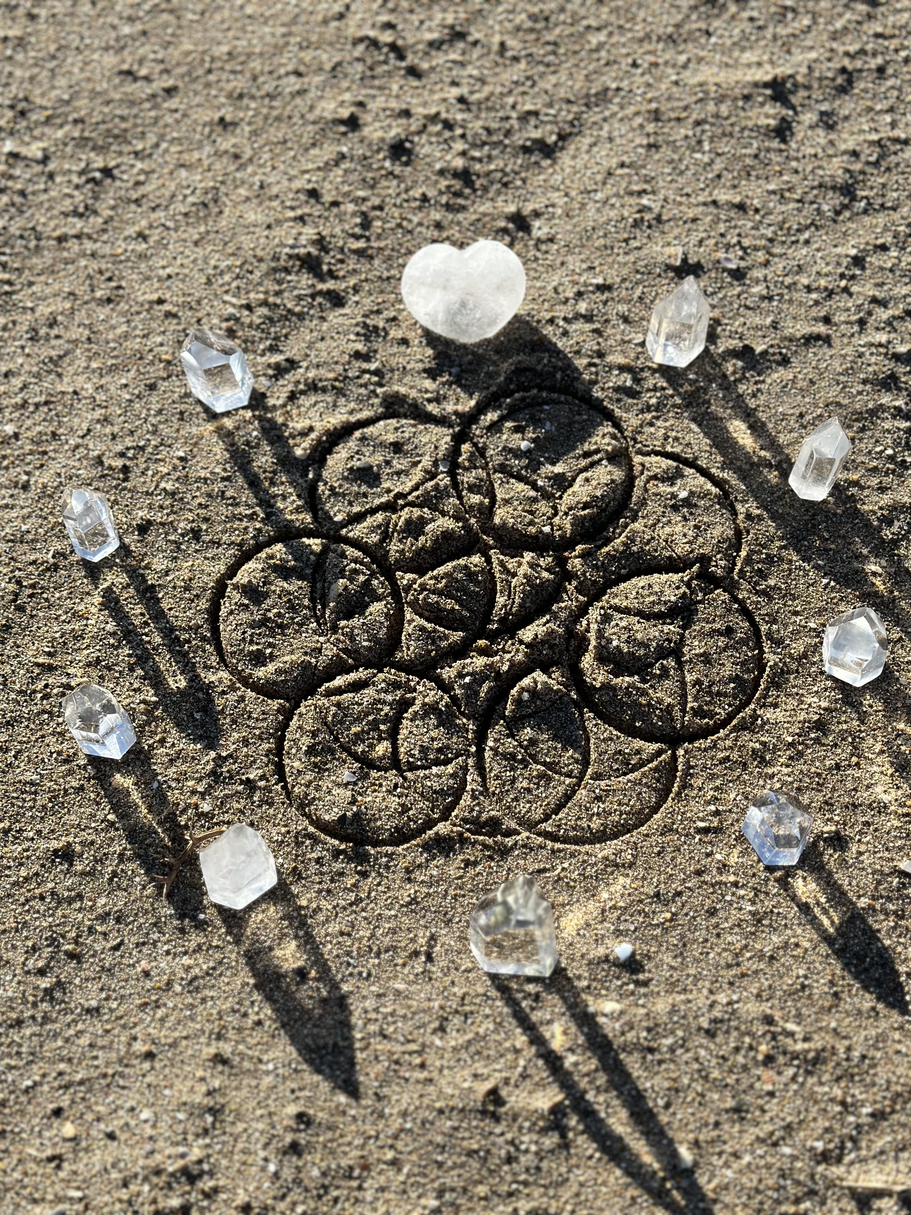 Geometría sagrada de Tameana en arena con cristales de cuarzo